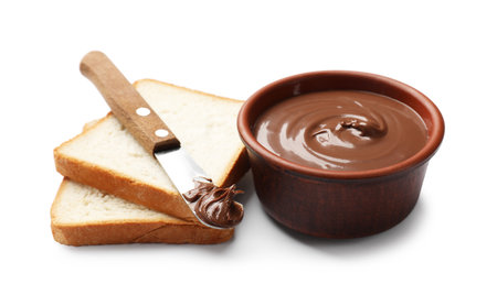 Tasty chocolate butter in bowl, slices of bread and knife isolated on whiteの写真素材