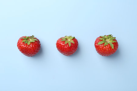 Fresh ripe strawberries on light background, flat layの写真素材