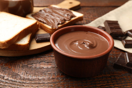 Tasty chocolate butter, pieces and bread on wooden table, closeupの写真素材