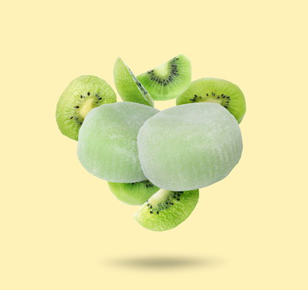 Yummy mochi and fresh kiwi fruits in air on beige backgroundの写真素材
