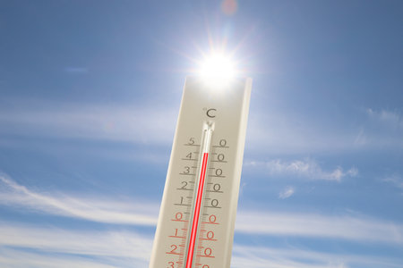 Extremely high temperature on thermometer against blue sky on sunny day. Summer weatherの写真素材