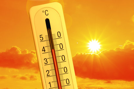 High temperature on thermometer against orange sky on sunny day. Hot summer weatherの写真素材