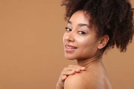 Portrait of beautiful Brazilian woman after spa treatment on light brown background. Space for text