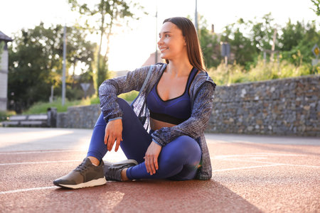 Happy woman in sportswear at stadium. Healthy lifestyle