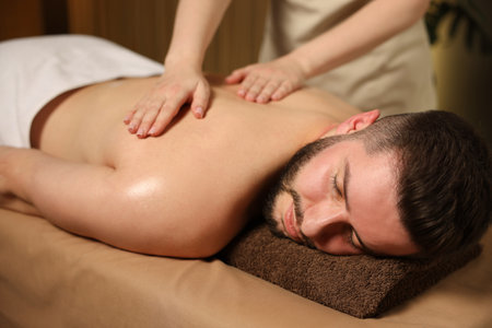 Man receiving relaxing massage in spa salonの写真素材