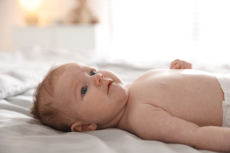 Cute newborn baby lying on bed, closeup