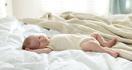 Cute newborn baby sleeping on bed indoors