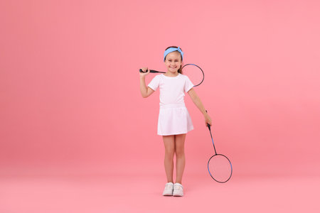 Little girl with rackets on pink backgroundの写真素材