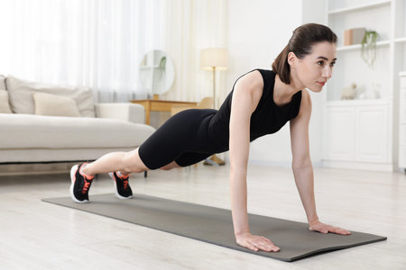 Woman doing plank exercise at home. Sport and healthy lifestyle