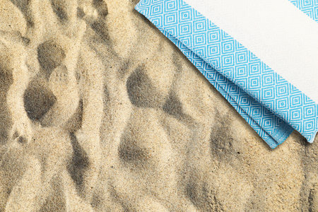 Folded beach towel on sand, top viewの写真素材