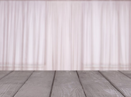 Empty wooden table against window with curtains in roomの写真素材
