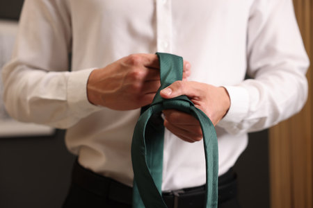 Man with stylish green necktie at home, closeupの写真素材