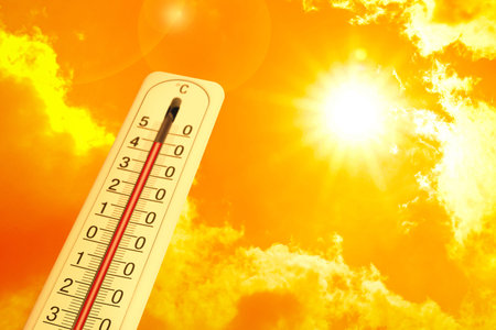 Extremely high temperature on thermometer against orange sky on sunny day. Severely hot summer...