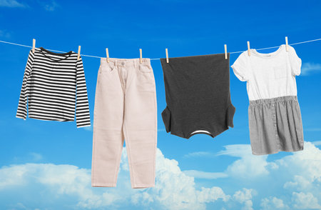 Different clothes drying on washing line against blue skyの写真素材