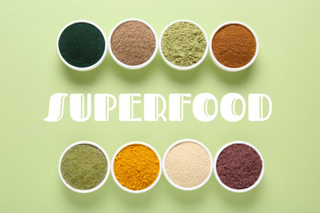 Superfood. Different powders in bowls on light green background, flat layの写真素材