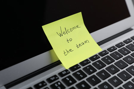 Sticky note with words Welcome To The Team on laptop, closeupの写真素材