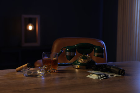 Gun, money, whiskey and other stuff on wooden table in mafia boss officeの写真素材