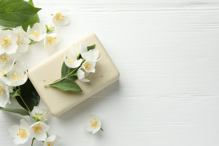 Soap bar and jasmine flowers on white wooden table, flat lay. Space for textの写真素材