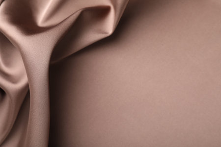 Crumpled light brown silk fabric as background, top viewの写真素材