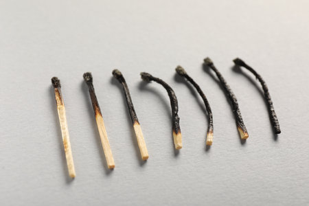 Burnt matches on gray background, closeup viewの写真素材