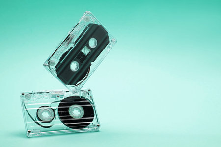 Audio cassettes in air on turquoise background, closeup. Space for textの写真素材