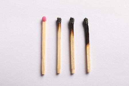 Burnt and whole matches on light gray background, flat layの写真素材