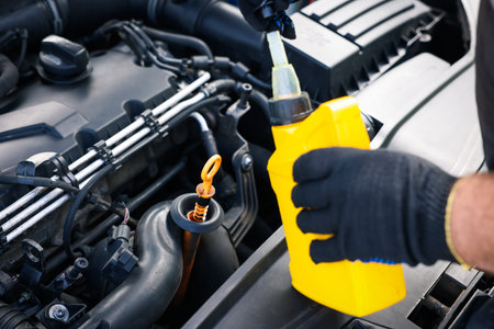Worker checking motor oil level in car with dipstick, closeupの写真素材