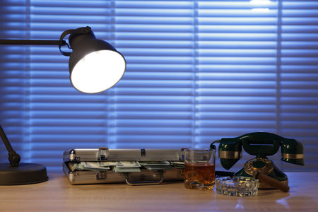 Mafia and criminal world. Money, whiskey, cigar and telephone on wooden table indoors