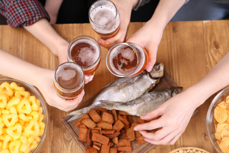 Friends with beer and snacks at wooden table, top viewの写真素材