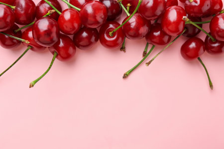 Fresh ripe cherries on pink background, flat lay. Space for textの写真素材
