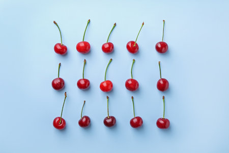 Fresh ripe cherries on light background, flat layの写真素材