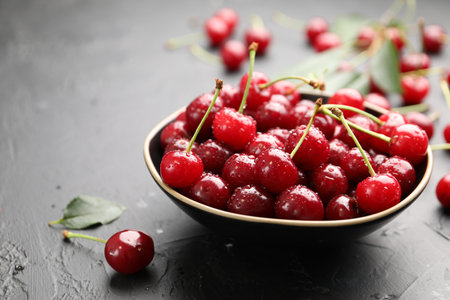 Wet ripe cherries on black table, closeupの写真素材