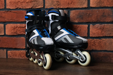 Pair of roller skates on wooden table near brick wallの写真素材