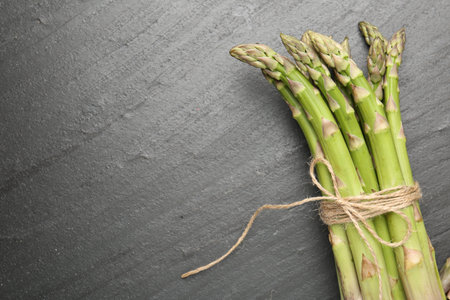 Fresh raw asparagus spears on black table, top view. Space for textの写真素材