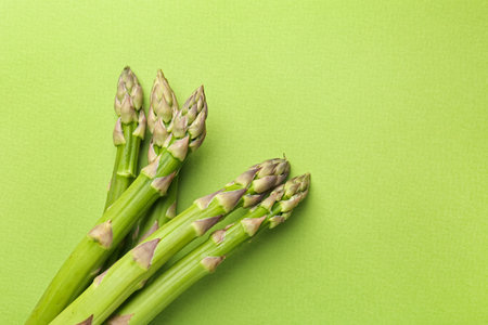 Fresh ripe raw asparagus on green background, top view. Space for textの写真素材