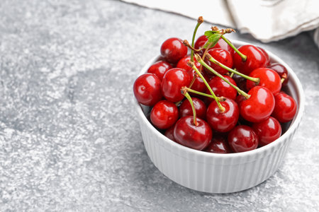Fresh ripe cherries on light table, closeup. Space for textの写真素材