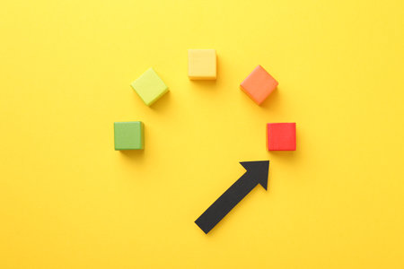 Maximum. Colorful cubes and arrow pointing at red one on yellow background, flat layの写真素材