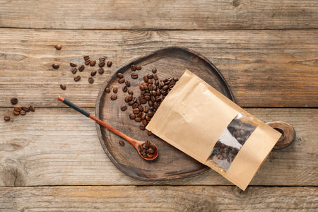 Zipper stand-up pouch with coffee beans on wooden table, flat lay. Mockup for designの写真素材