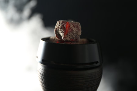 Smoldering charcoal cubes in hookah holder and smoke on dark background, closeupの写真素材