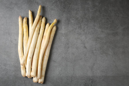 Many raw asparagus spears on gray table, flat lay. Space for textの写真素材