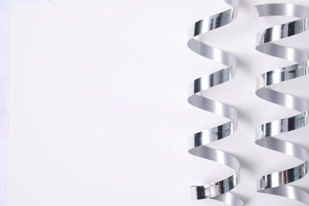 Shiny party streamers on white background, flat lay. Space for textの写真素材