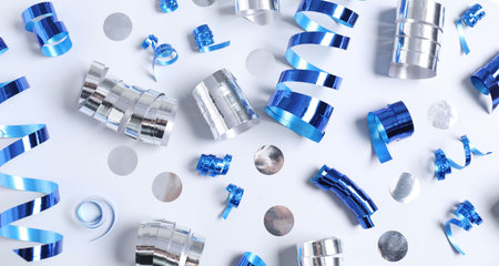 Shiny party streamers and confetti on white background, flat layの写真素材
