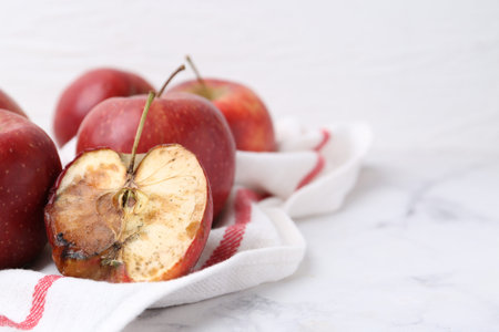 Spoiled apple and good ones on white table, closeup. Space for textの写真素材