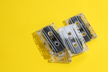 Audio cassettes with magnetic tapes on yellow background, above view. Space for textの写真素材