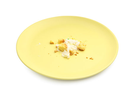 Dirty plate with crumbs and cream isolated on whiteの写真素材