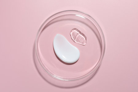Different cosmetic products in Petri dish on pink background, top viewの写真素材