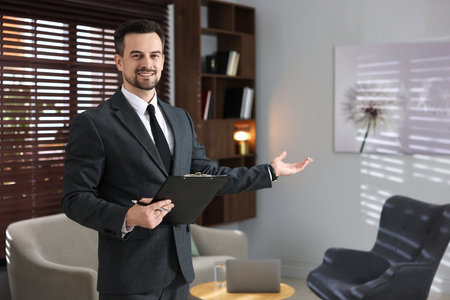 Professional psychologist with clipboard inviting to his office. Space for textの写真素材