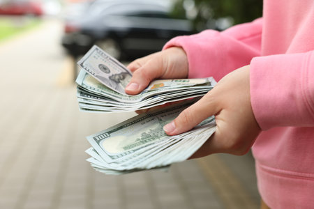 Woman counting her money outdoors, closeup viewのeditorial素材