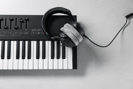 MIDI keyboard with headphones on white table, top viewの写真素材