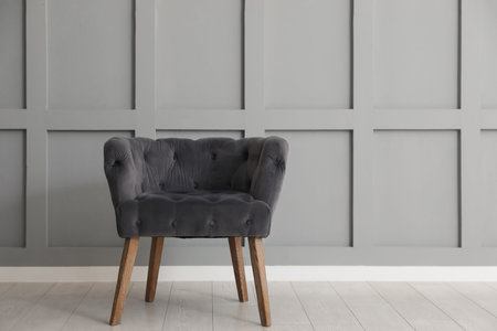 Comfortable armchair near light gray wall indoors, space for text